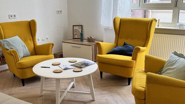 Gesprächsbereich mit gelben Sesseln in der DHI Hypnosepraxis Aschaffenburg