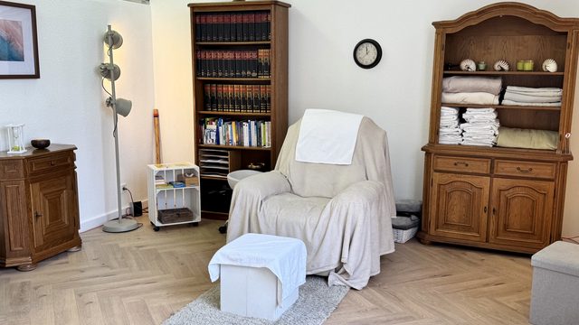 Hypnosesessel mit Fußhocker und Holzregalen in der DHI Hypnosepraxis Aschaffenburg